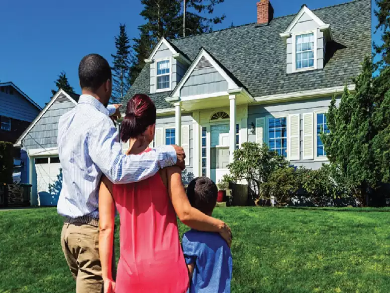 Picture of a young family looking from the road at a possible future home.
